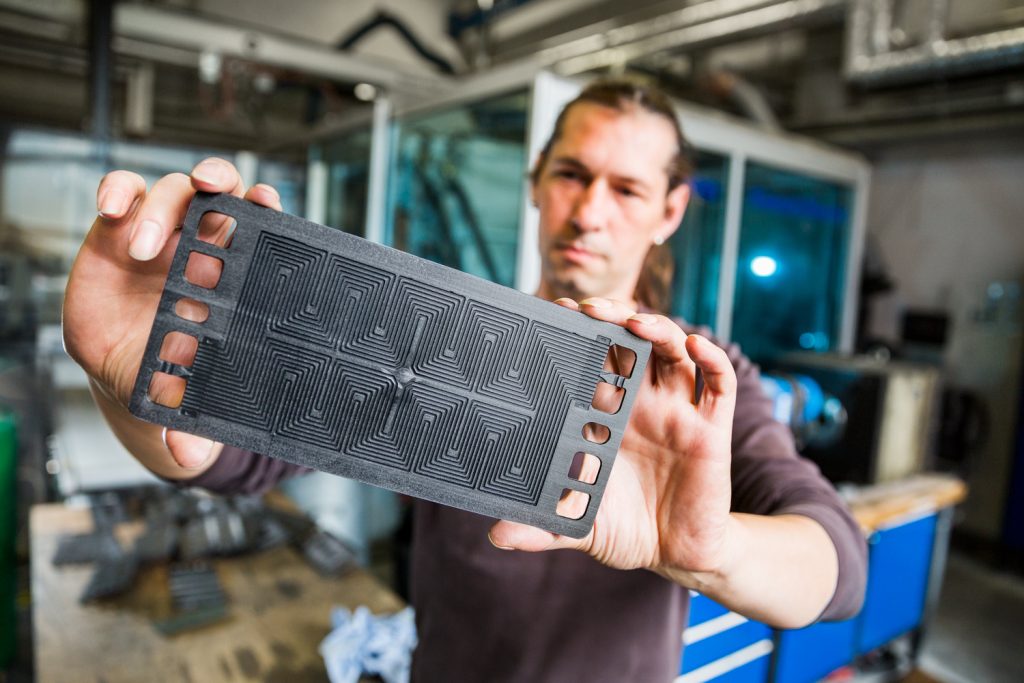 ZBT-Mitarbeiter hält graphitische Bipolarplatte in die Kamera