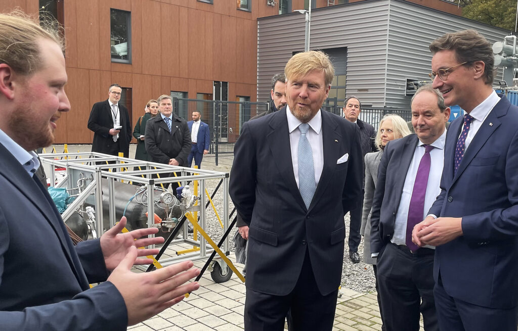 König Willem Alexander der Niederlande und NRW-Ministerpräsident Hendrik Wüst lassen sich das Wasserstoff-Testfeld des ZBT von einem Mitarbeiter erklären.