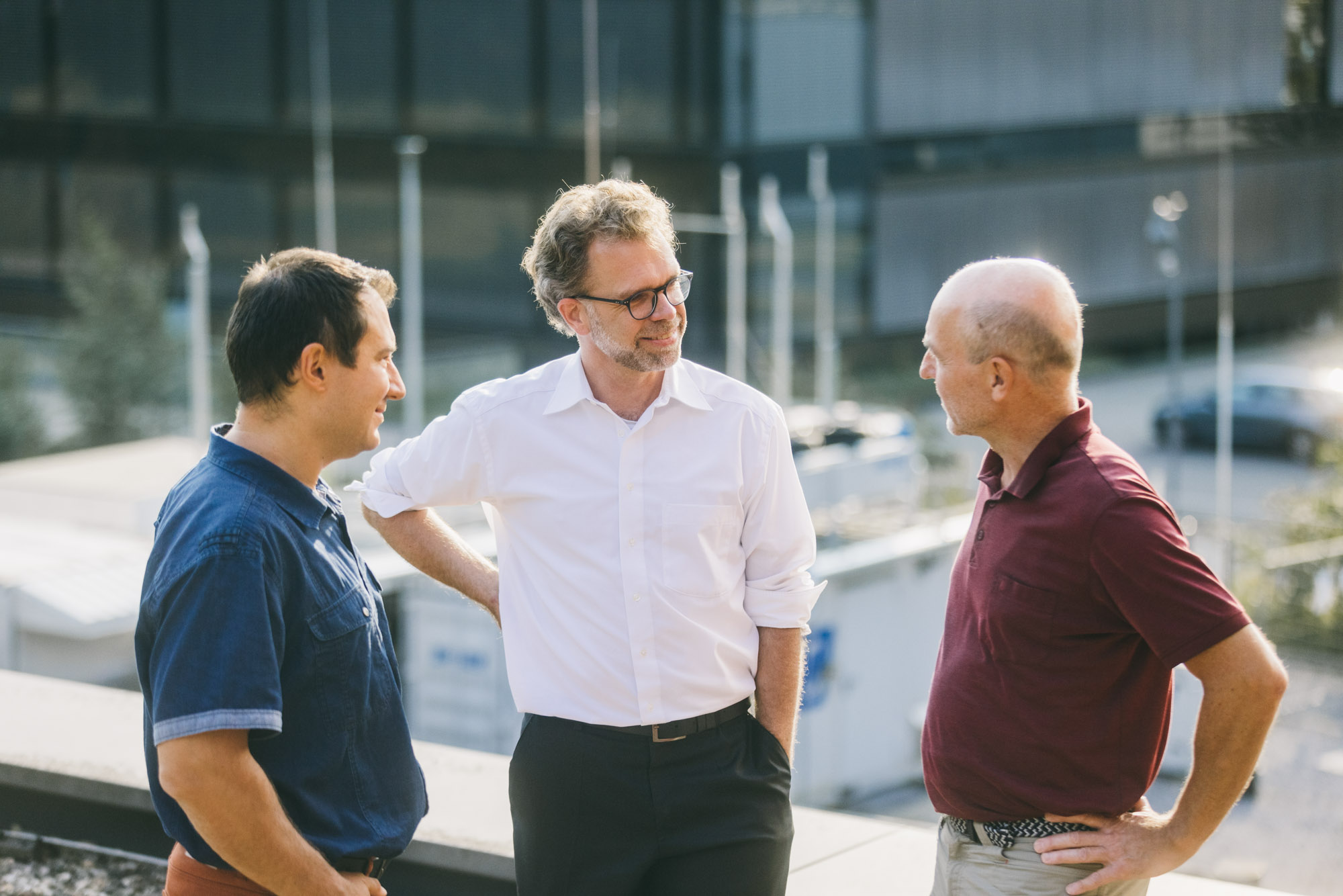 drei Personen beraten sich auf der Dachterrasse über dem Wasserstofftestfeld des ZBT