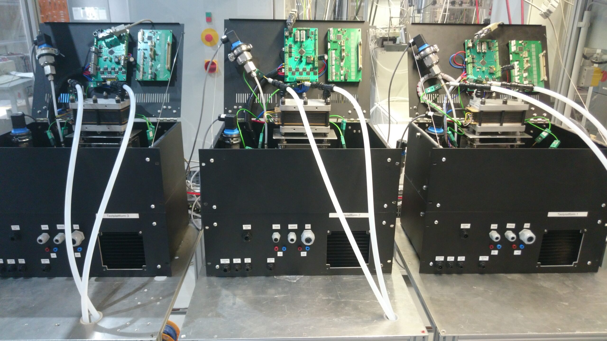 Abgebildet sind 3 Brennstoffzellensysteme in einer Laborumgebung.