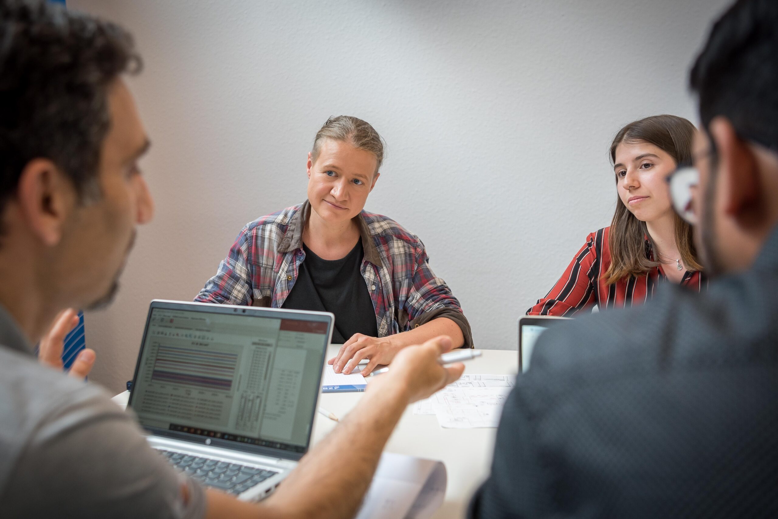 Eine Gruppe von Wissenschaftler:innen diskutiert über Publikationen zu Wasserstoff, Brennstoffzellen und Elektrolyse