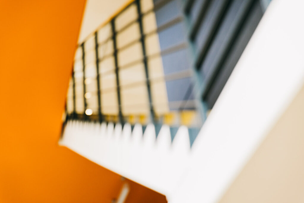 Blick ins Treppenhaus, orange Wand und Handlauf